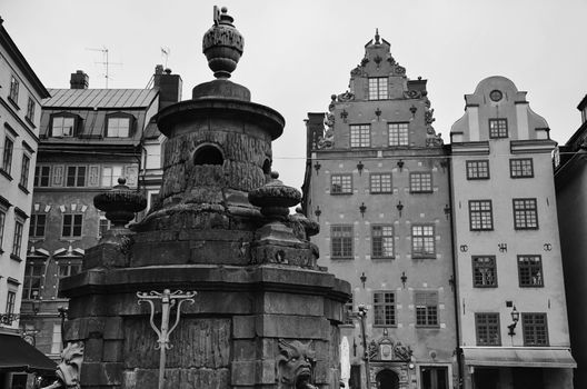 Statue with water outlets at Stortorget, Stockholm, Sweden in black and white photography