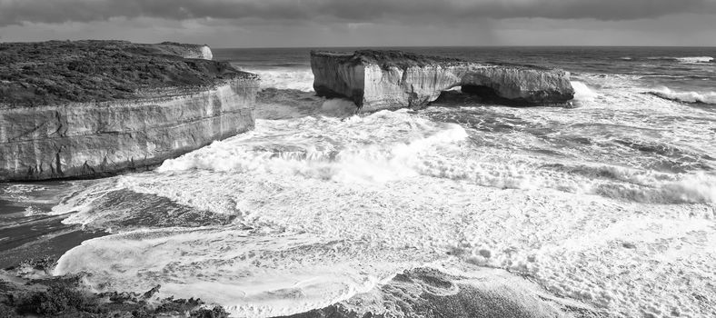 View of the London Bridge on Great Ocean Road during the day. Black and White.