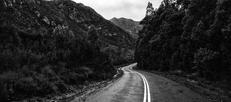 Road and mountains out in the Tasmanian country during winter on a rainy day. Black and White.