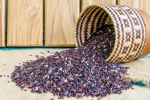 Hom Nil (black jasmine rice) in kratip on wood background