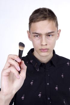 Young man makeup artist at work on a white background