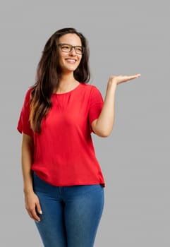 Lovely happy woman showing something on her hand, isolated over white background 