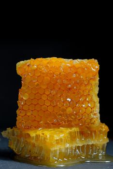 Honeycomb and honey on black ardesia plate