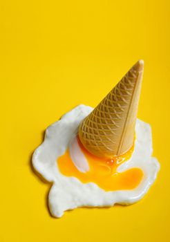 Ice cream cone dropped concept with fried egg