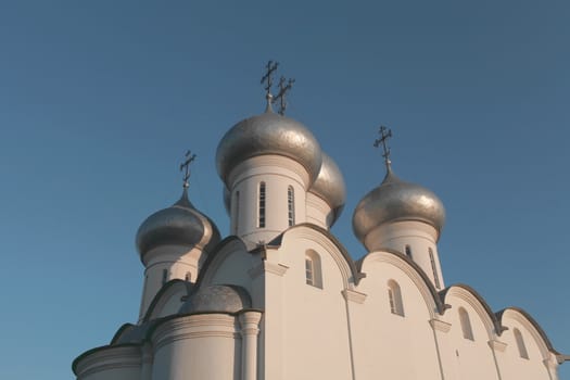 white church with silver domes against the blue sky