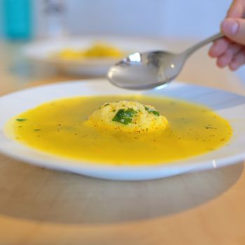 Soup with dumplings on table