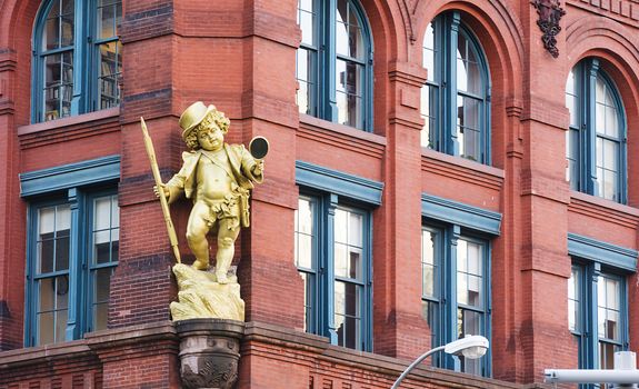 New York, USA, november 2016: a golden puck statuette by Henry Baerer decorating the puck building on lower manhattan