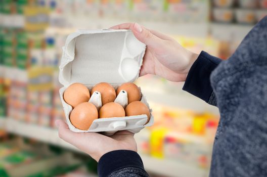 Man holding egg box in supermarket. egg box buy carton man hold checking consumer concept