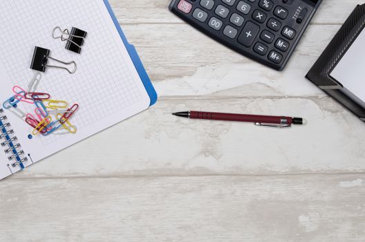 Business desk in office top view. Table with calculator, notepad, and office supplies. Copy space website banner concept