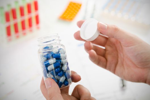 Person opens a bottle of drugs. pill bottle capsule medicine healthcare medical patient treatment concept