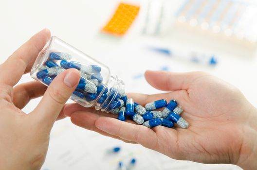 Person pouring out pills on hand. pill doctor hand pour capsule bottle closeup pills concept