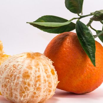 Tangerine and peeled tangerine on white background.