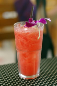 a watermelon shake with a straw and a mint leaf.