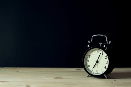 Retro alarm clock with copy space on wooden table.