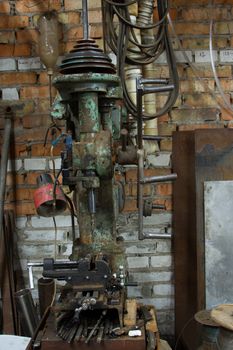 Old and dirty drilling machine in factory.