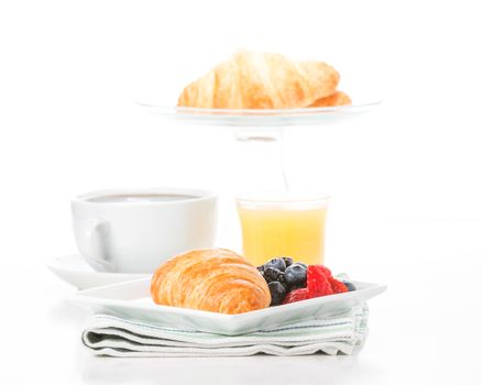 Fresh croissant and fruit served with coffee and orange juice.