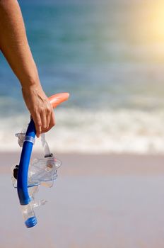 Woman Holding Snorkeling Gear on the shoreline.