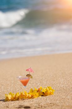 Tropical Drink and Lei on a Sandy Beach Shoreline.