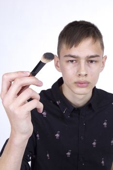 Young man makeup artist at work on a white background