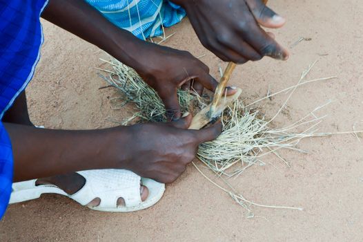 Lighting a fire with pieces of wood and straw by Masais