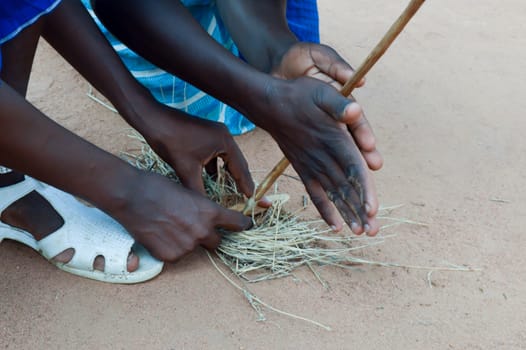 Lighting a fire with pieces of wood and straw by Masais