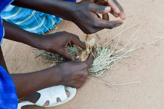 Lighting a fire with pieces of wood and straw by Masais