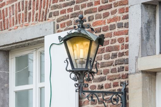 Medieval illuminated street lantern made of wrought iron.