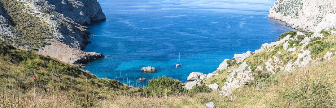 Panorama, lonely bay with sailing ship on the island of Majorca, Spain.
