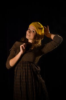 Beautiful, fashionable, glamorous, nice, attractive,pretty,nice,cheerful,smiling,parisian girl,woman,student,teenager,lady with cite smile,face,well-dressed and yellow beret,cap,gesture,pose,posing.Portrait.Black background.Photo studio.Paris,manners