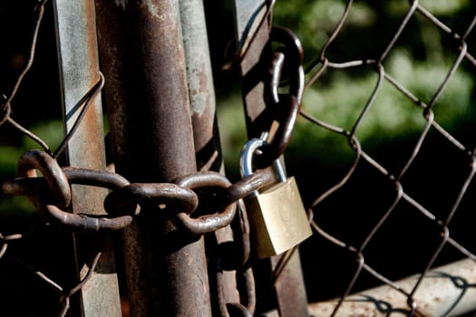 Close-up on a rusty lock and chainlink fence