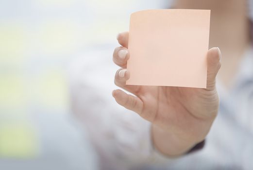 Woman holding sticky note with empty space