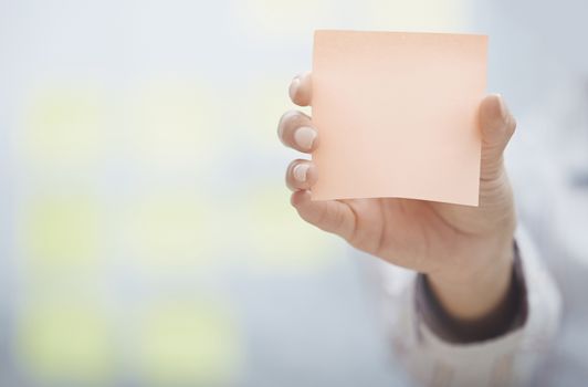 Woman holding sticky note with empty space