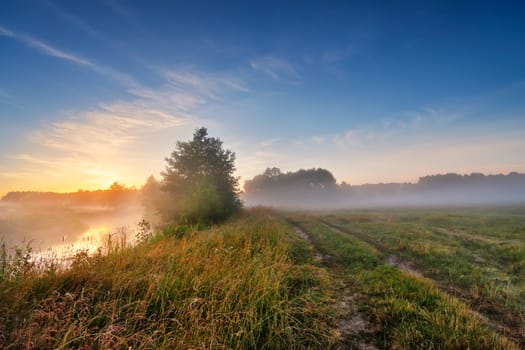 Summer misty sunrise on the river. Foggy river in the morning. Summer misty dawn. Foggy morning.