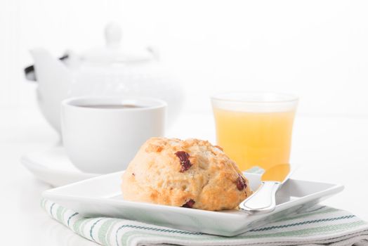 Fresh cranberry lemon scone served with coffee and juice.