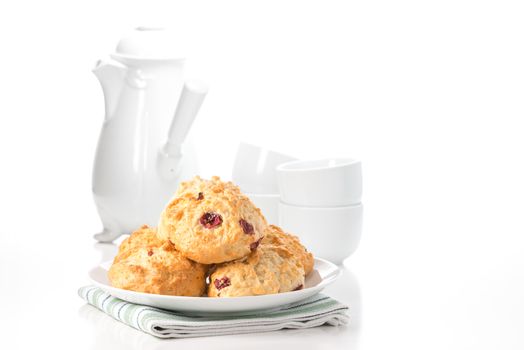 Fresh lemon cranberry scones with a coffee pot and cups in the background.