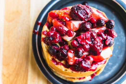 waffles and chocolate icecream with fresh berries on wooden tray