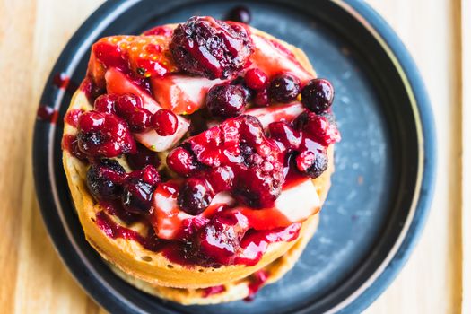 waffles and chocolate icecream with fresh berries on wooden tray