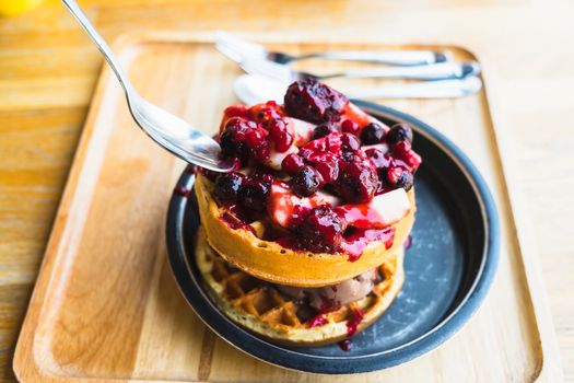 waffles and chocolate icecream with fresh berries on wooden tray