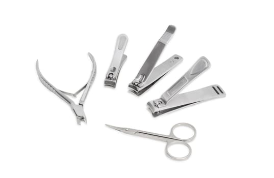 One nail clipper in the pliers style, three nail clippers different sizes in the compound lever style and nail scissors made of stainless steel on a light background
