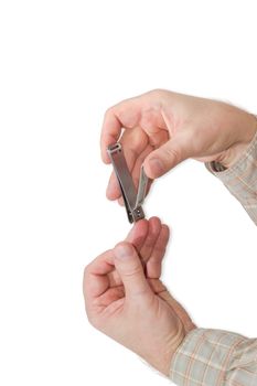 Nail clipper in the compound lever style made of stainless steel in male hands during trimfinger nails on a light background
