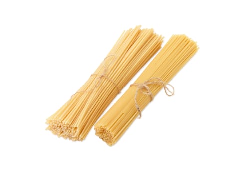 Two bundles of different uncooked dried long pasta on a light background
