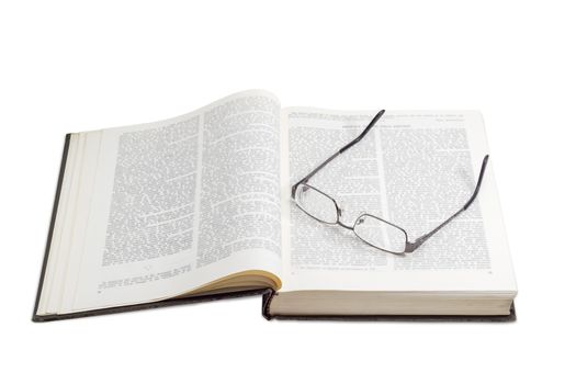 Modern pair of eyeglasses with single vision lenses and metal frame on a open book on a light background
