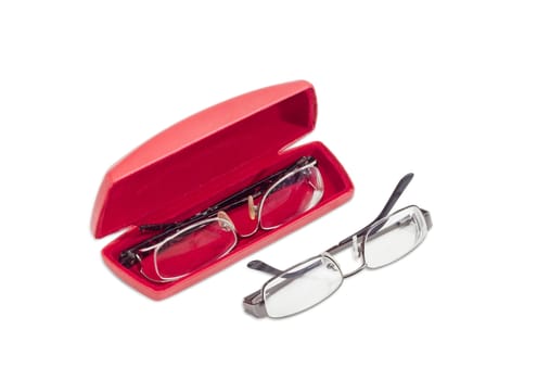 One modern pair of women's eyeglasses in open red spectacle case and one pair of eyeglasses with metal frame beside on a light background
