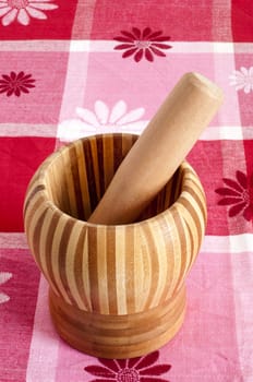 a wooden mortar over a patterned fabric