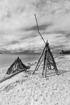 Driftwood teepees on the beach in summer