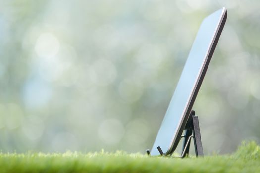 Digital tablet on a lawn. Horizontal photo