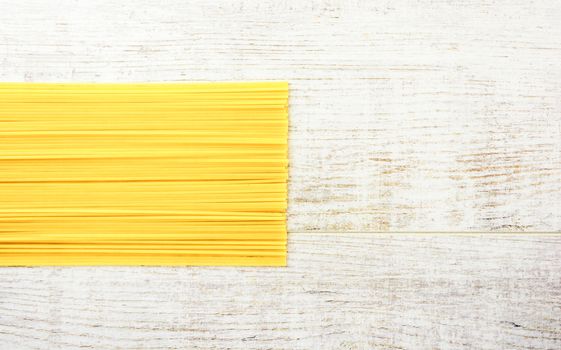 Italian raw pasta on a white surface. Top view, copy space.