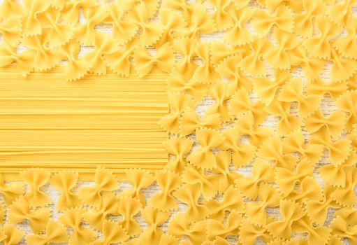 Italian raw pasta on a white surface. Top view, copy space.