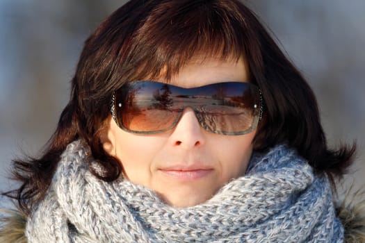 portrait of happy smiling middle age woman without makeup in winter time with sunglasses
