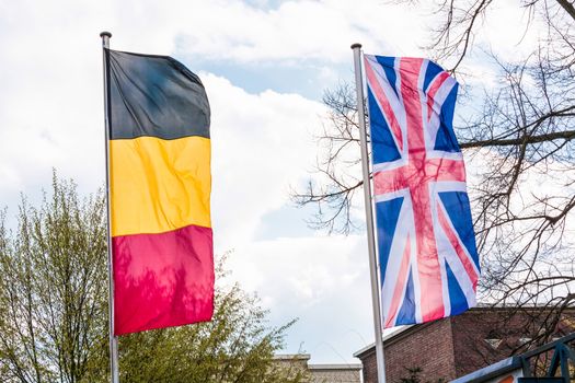 Several Europe countries flags arranged in front of a blue sky.